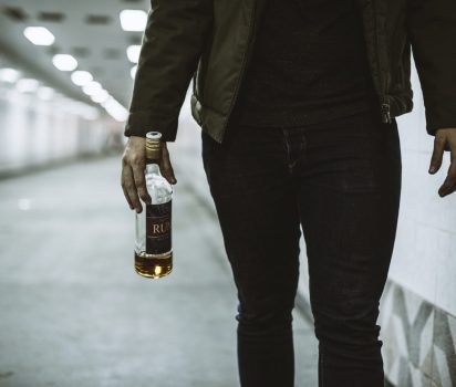 Alcoholic Homeless Holding Liquor Bottle